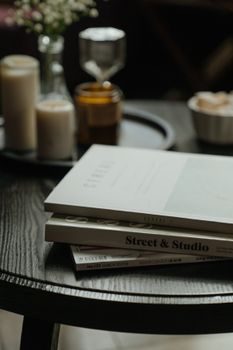 pile de magazines de décoration et jardin posés sur une table en bois, lumière naturelle douce