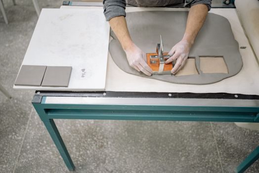 stagiaires en atelier posant du carrelage sous la supervision d'un formateur, outils et carreaux étalés sur un plan de travail