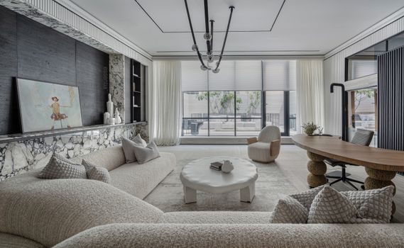 salon rénové avec mobilier sur mesure en bois clair, grandes fenêtres laissant entrer la lumière naturelle, palette de couleurs neutres